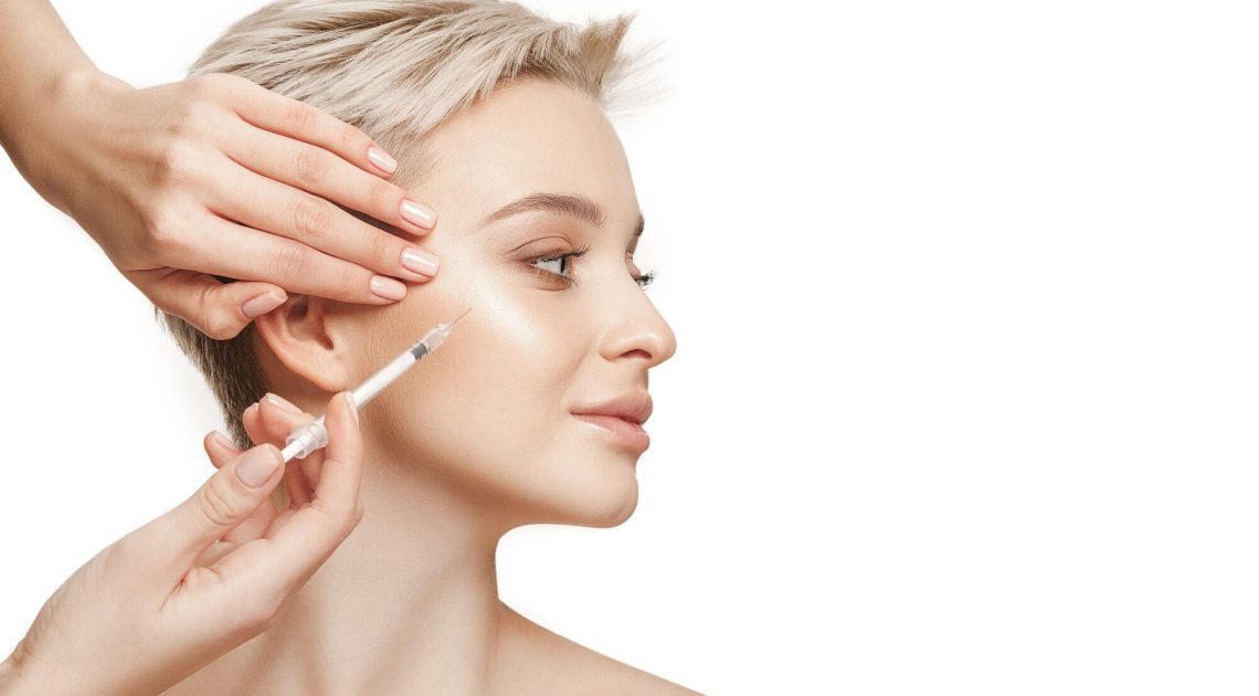 people-lips-cosmetology-plastic-surgery-beauty-concept-beautiful-young-woman-face-hand-with-syringe-making-injection (1)