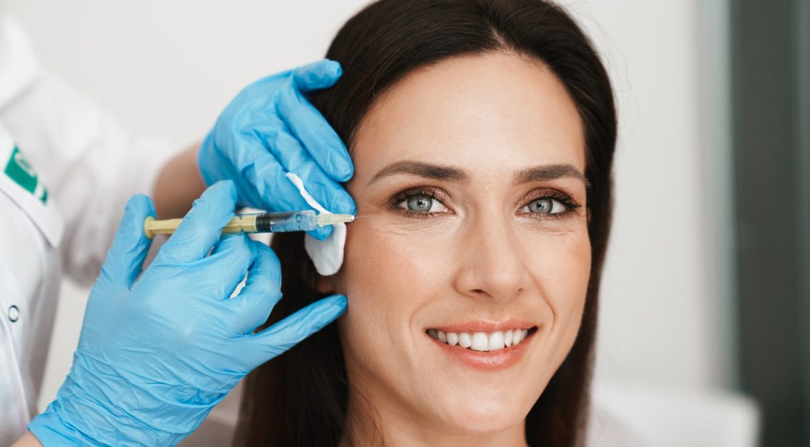 portrait-smiling-woman-getting-mesotherapy-treatment-face-by-specialist-gloves-beauty-salon