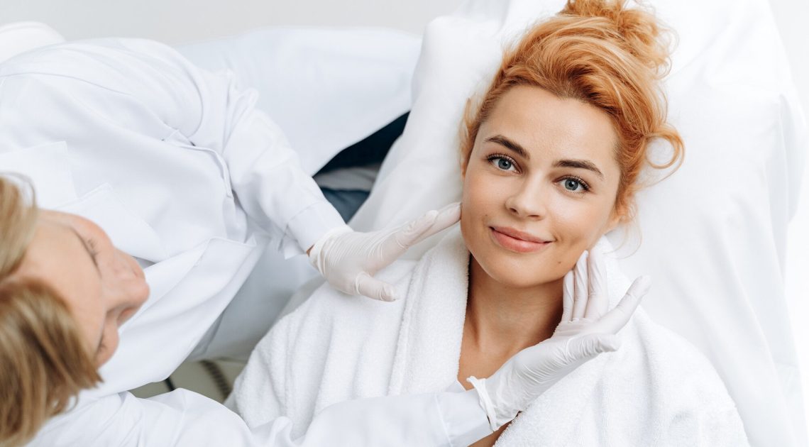 top-view-hands-medical-worker-rubber-gloves-touching-face-young-woman-during-treatment-stock-photo